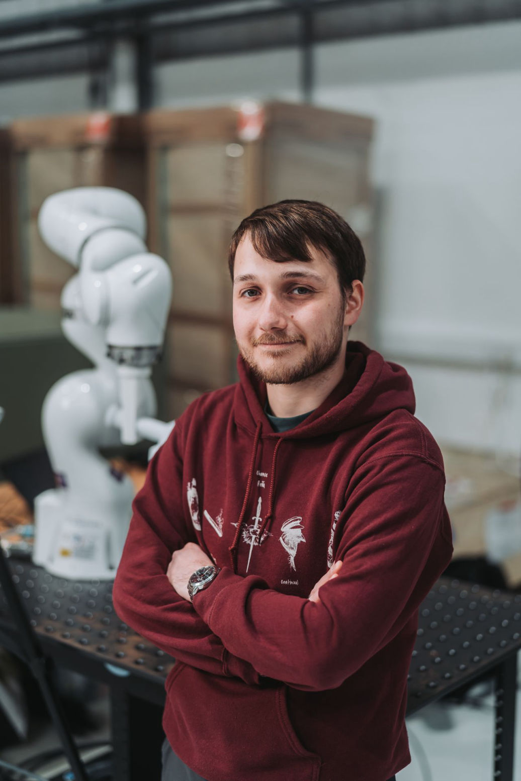 Joshua standing in front of a robot